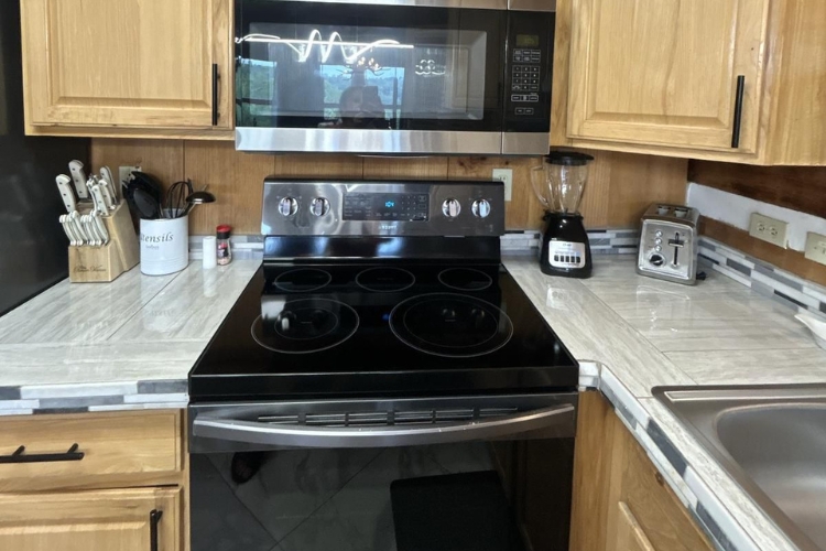 A professional cleaner providing thorough home cleaning in Sevierville, TN, dusting a modern living room.